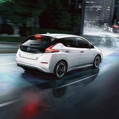 2024 Nissan LEAF in white on city streets at night to illustrate E-pedal