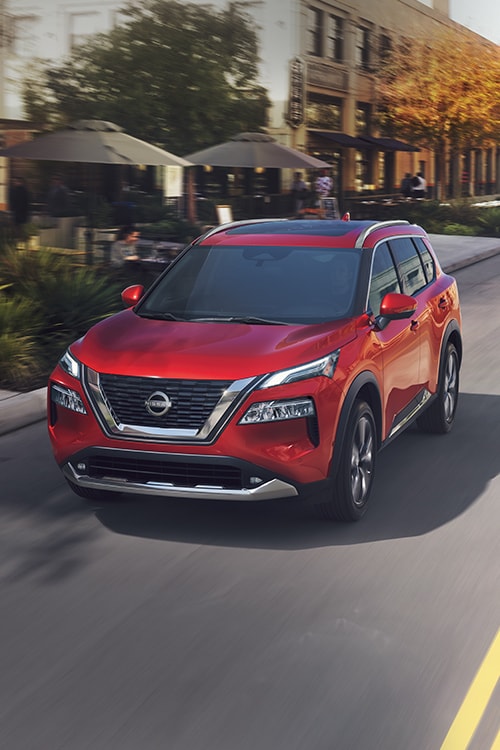 2023 Nissan Rogue red driving in city