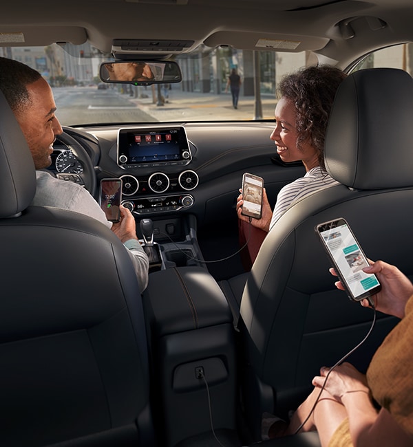 2021 Nissan Sentra 內飾，乘客在使用智能手機