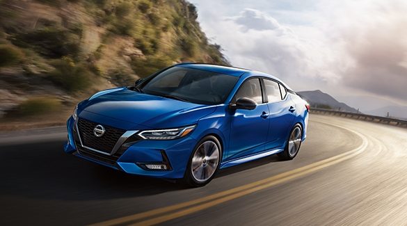 2023 Nissan Sentra in Electric Blue Metallic taking a curve on a mountain road.