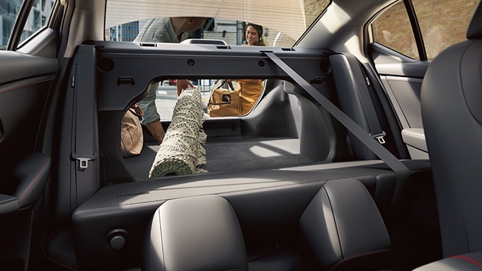 2024 Nissan Sentra displaying people putting a rug into the cargo space.